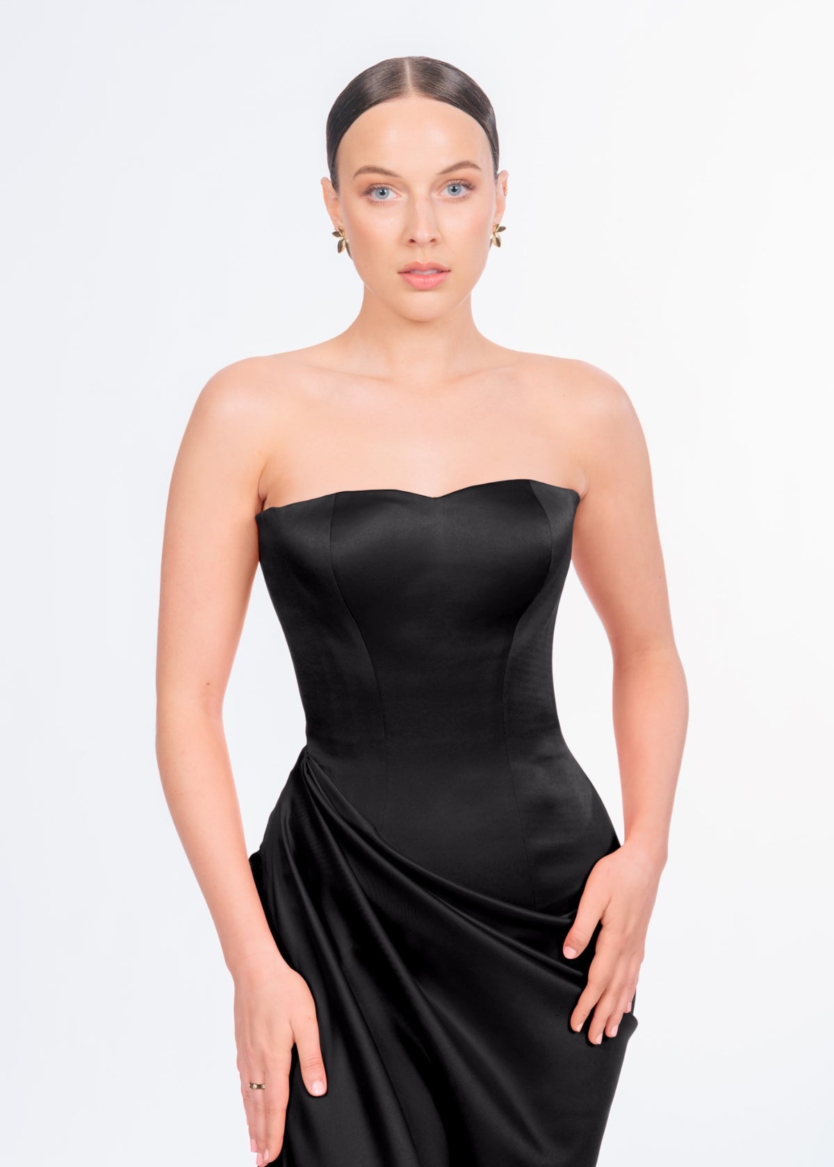 Woman wearing a black strapless dress Lia Stublla Bianca Dress on a light gray background